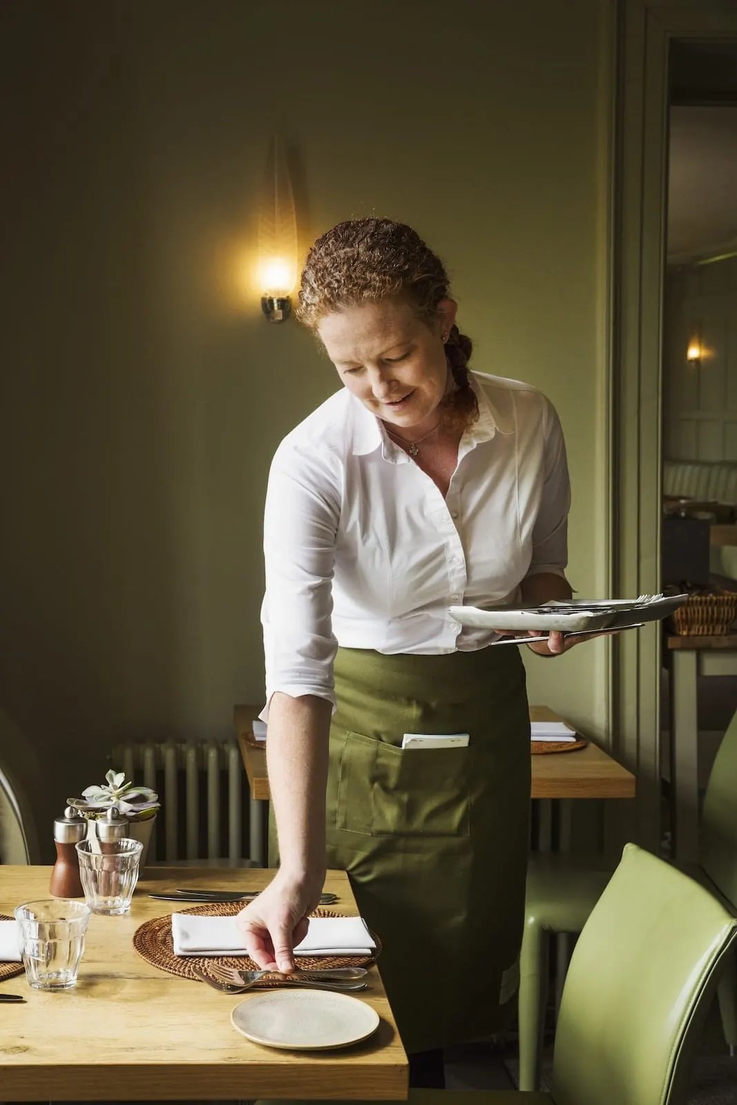 Waitress setting a table in the restaurant